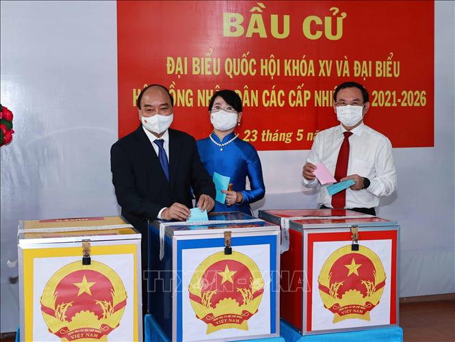 Chủ tịch Nước Nguyễn Xuân Phúc cùng Phu nhân và Bí thư Thành uỷ TP Hồ Chí Minh Nguyễn Văn Nên bỏ phiếu bầu đại biểu Quốc hội Khóa XV và đại biểu Hội đồng Nhân dân các cấp nhiệm kỳ 2021-2026. Ảnh: Thống Nhất - TTXVN