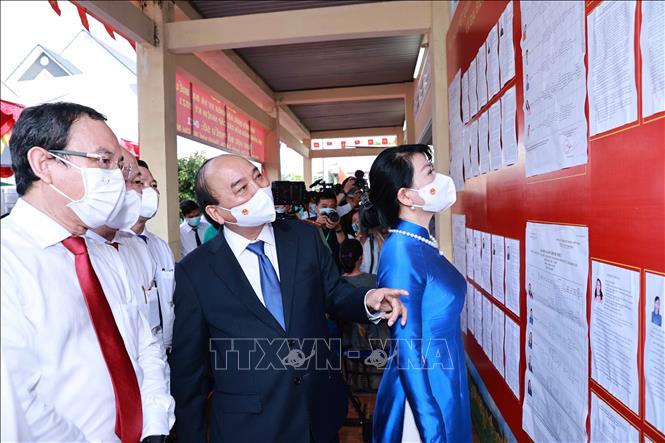 Chủ tịch Nước Nguyễn Xuân Phúc và Phu nhân cùng đồng chí Nguyễn Văn Nên, Ủy viên Bộ Chính trị, Bí thư Thành uỷ TP Hồ Chí Minh xem danh sách ứng cử viên. Ảnh: Thống Nhất - TTXVN